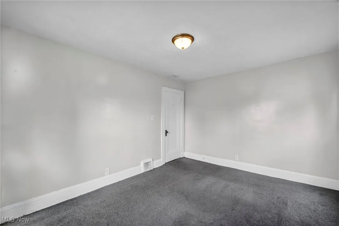 Carpeted empty room with baseboards