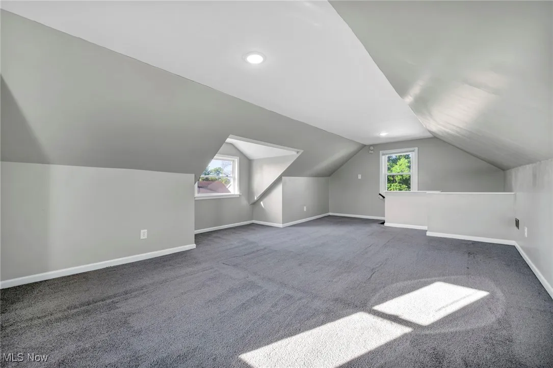 Bonus room with vaulted ceiling and carpet flooring