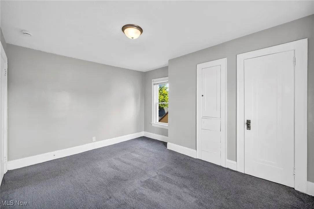 Unfurnished bedroom with carpet flooring and baseboards