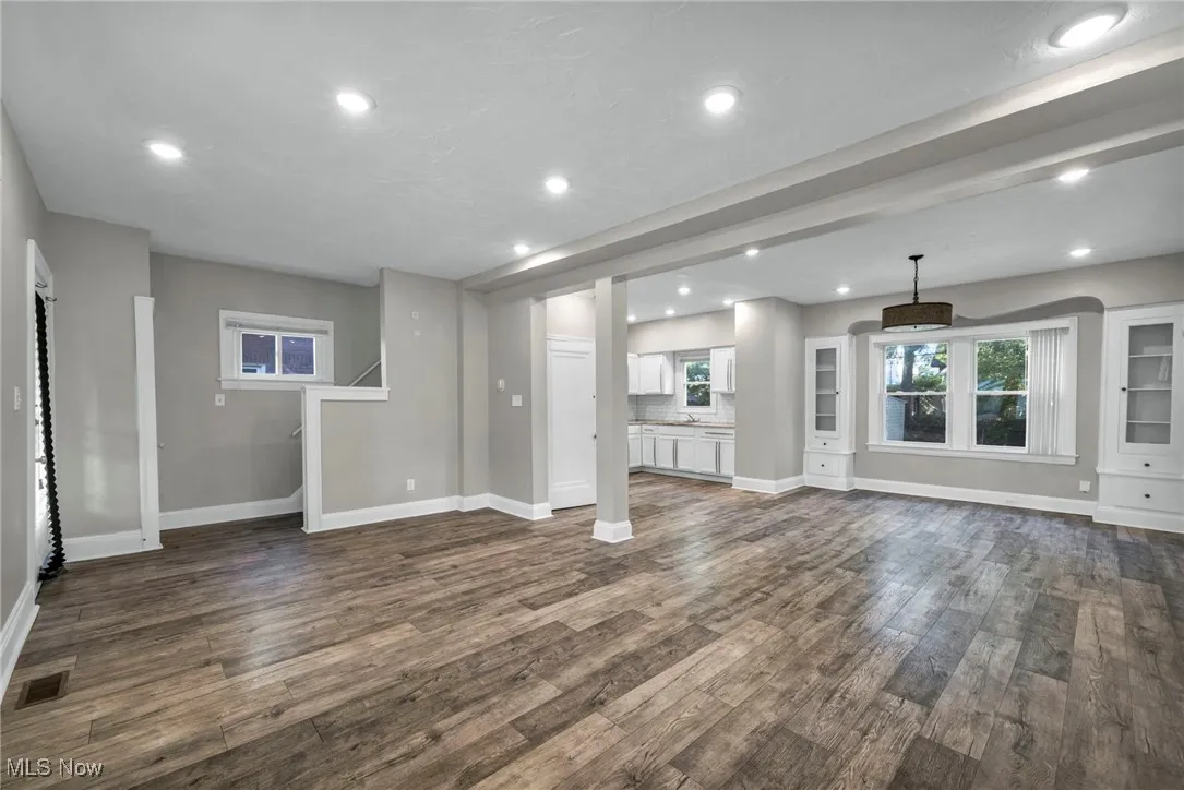 Unfurnished living room with recessed lighting and dark wood-style flooring