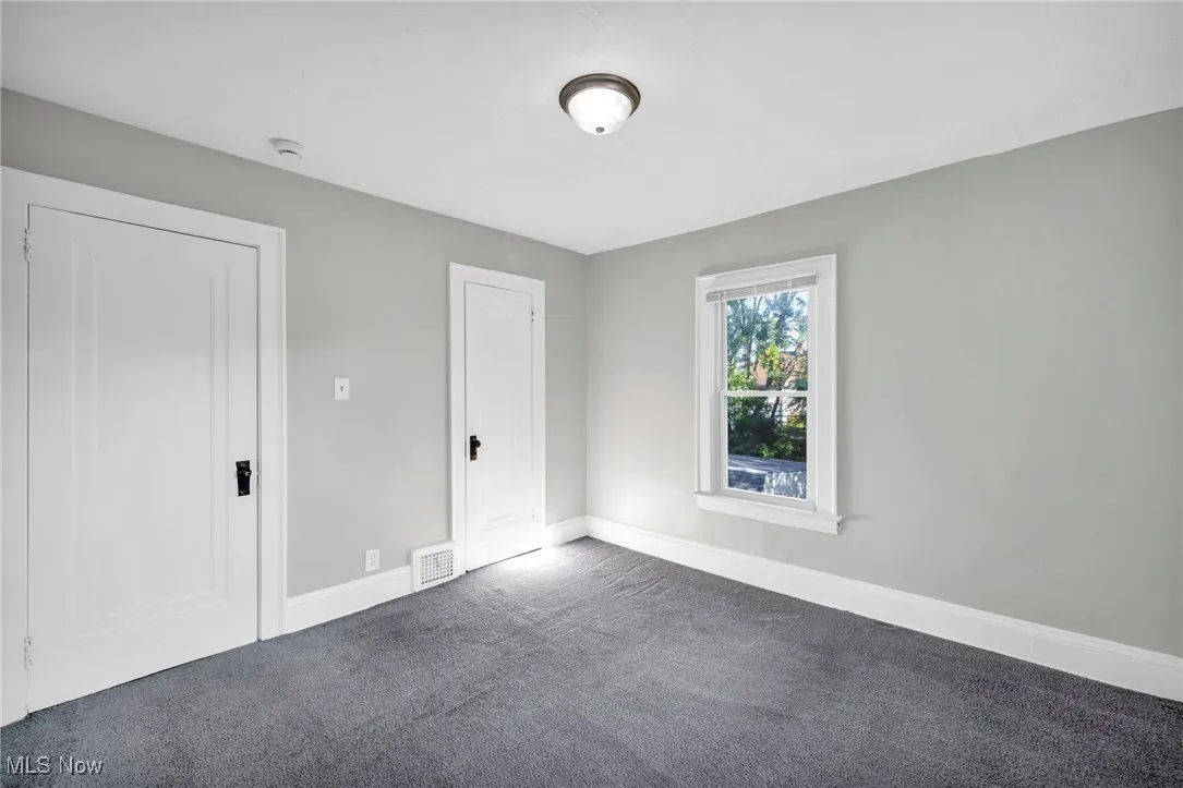 Unfurnished bedroom featuring carpet flooring and baseboards