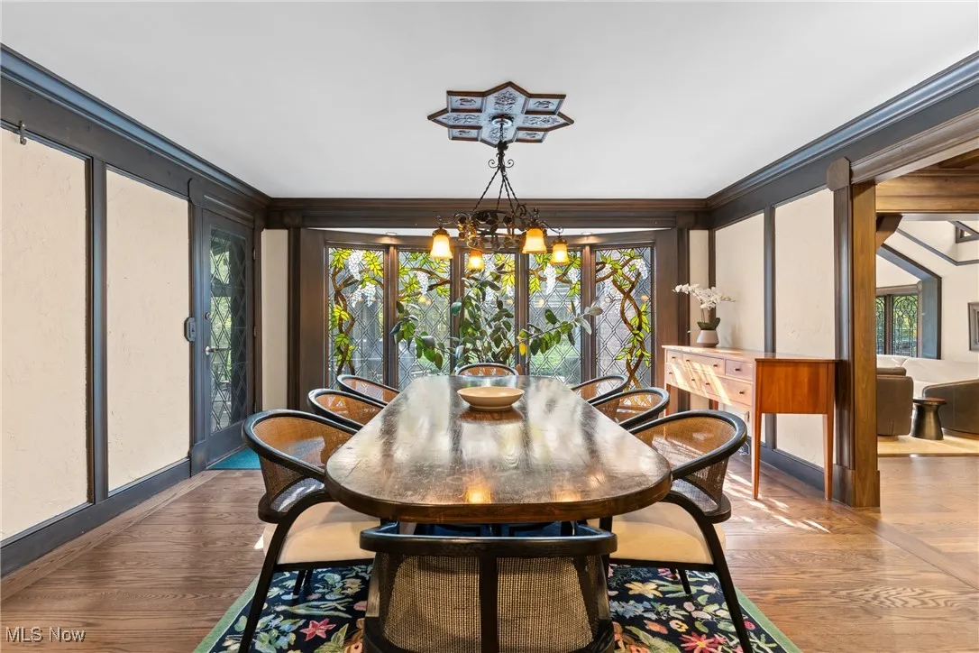 Dining room featuring wood finished floors, a chandelier, and ornamental molding