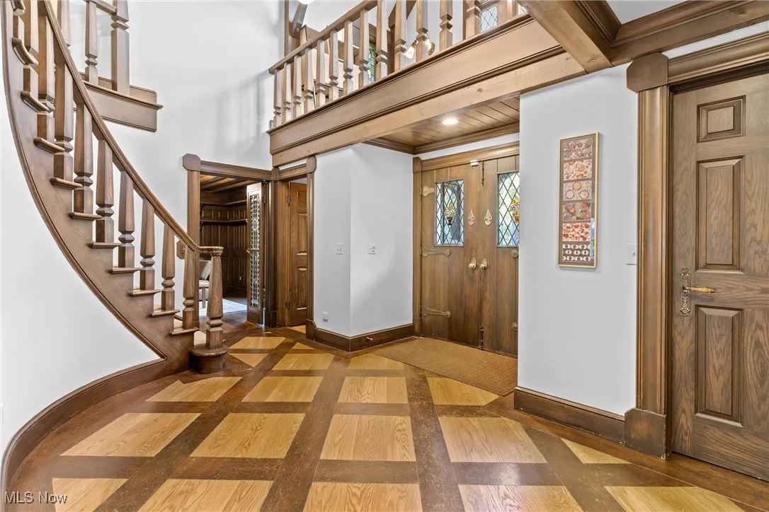 Entrance foyer featuring inlaid floor details and stairway