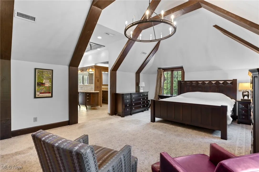 Bedroom featuring multiple windows, light colored carpet, recessed lighting, a chandelier, and ensuite bathroom