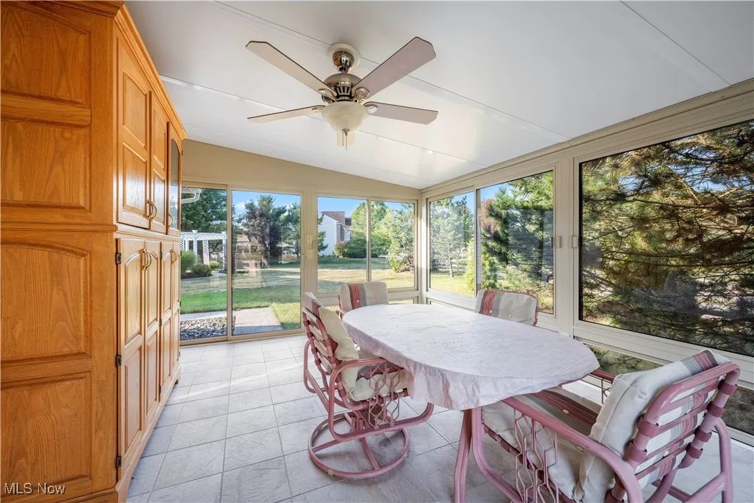 Sunroom / solarium featuring ceiling fan, lofted ceiling, and outdoor dining area