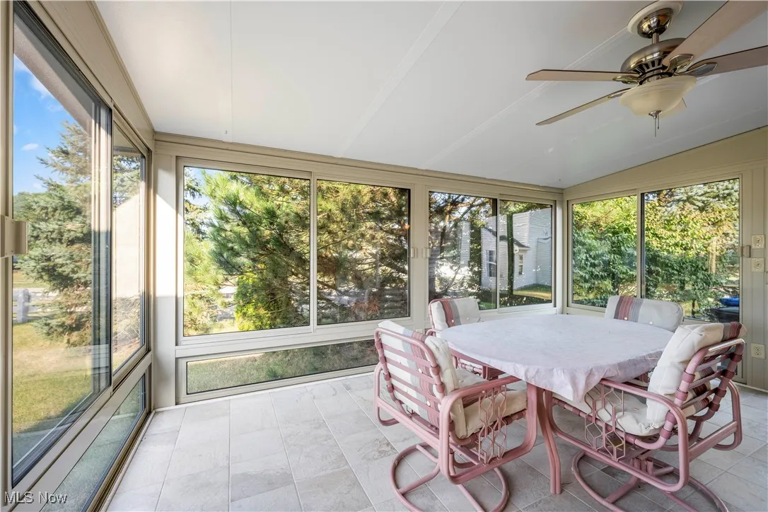 Sunroom / solarium featuring outdoor dining space, a ceiling fan, and lofted ceiling