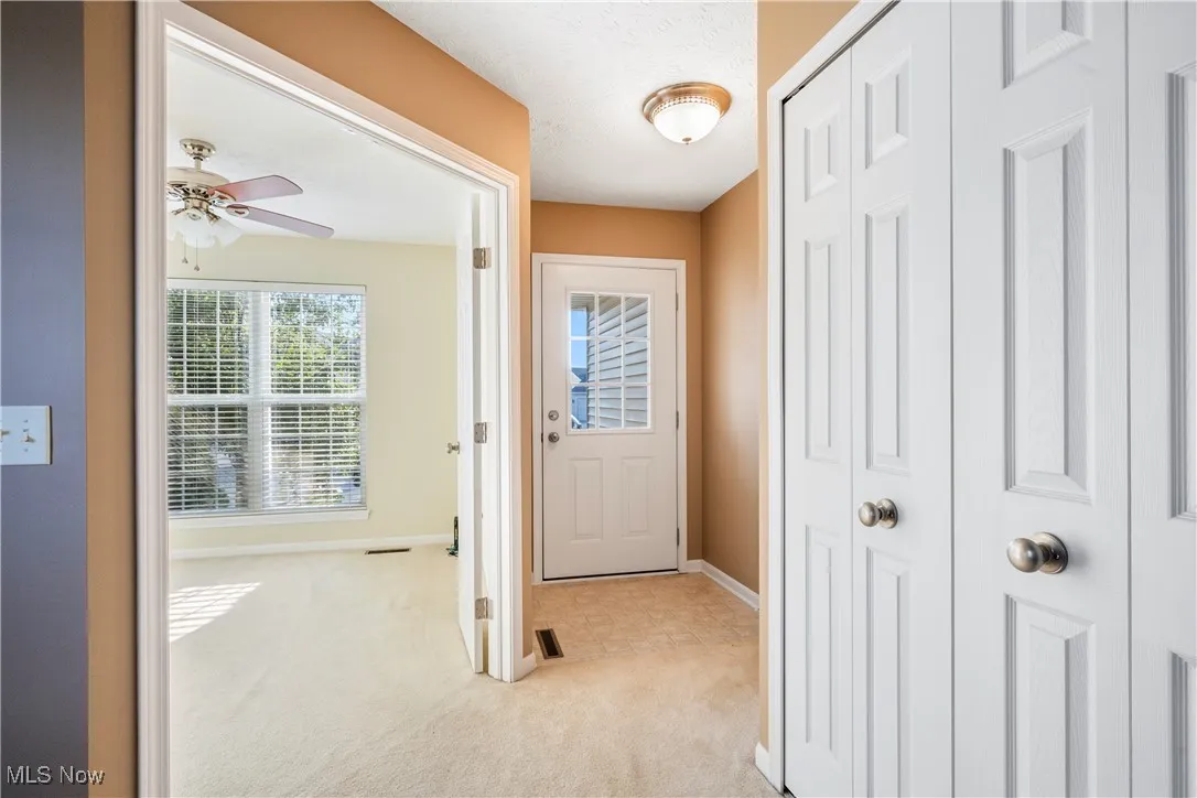 Front hallway opening to living room and den/office