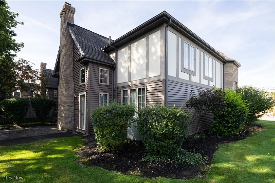 View of side of property with a yard and a chimney