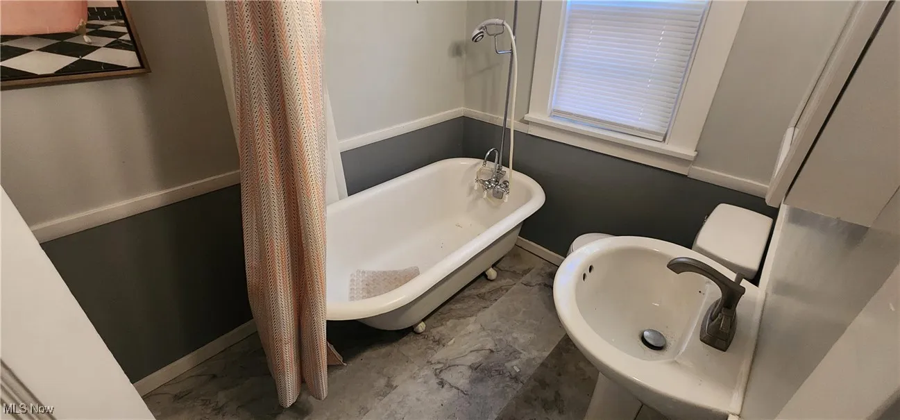 Bathroom featuring baseboards and marble finish flooring