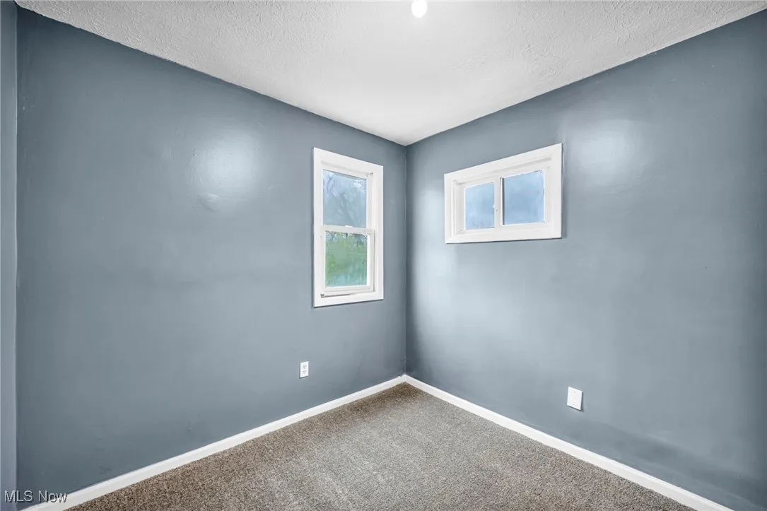 Empty room featuring carpet and a textured ceiling