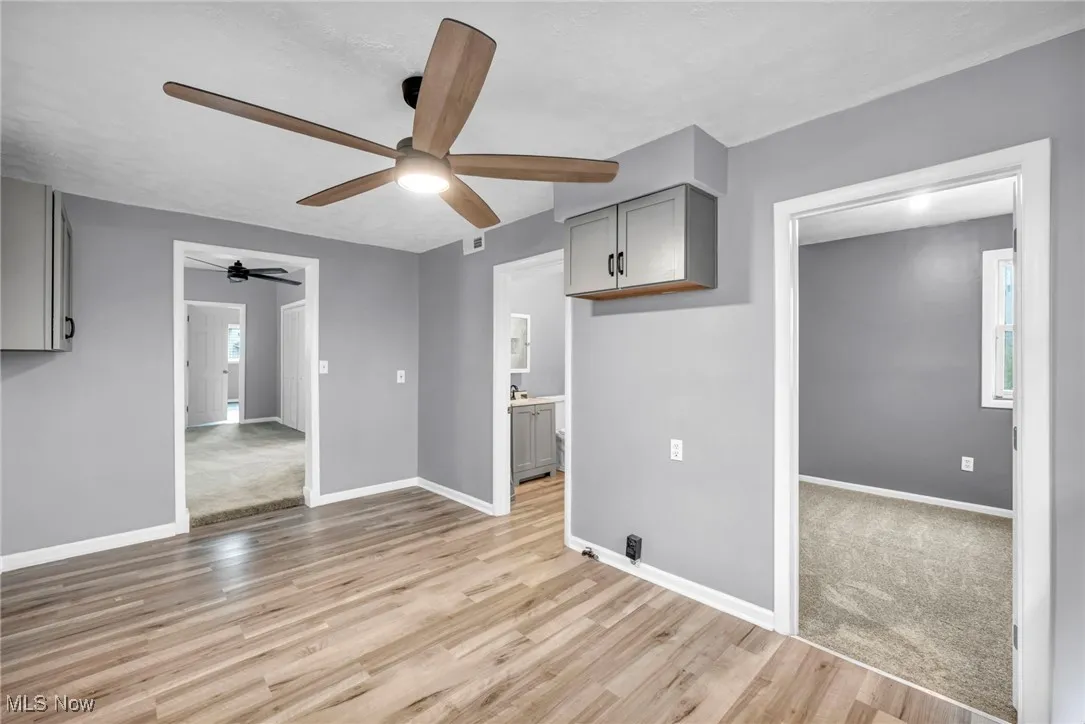 Unfurnished living room with light wood-style floors, healthy amount of natural light, and ceiling fan