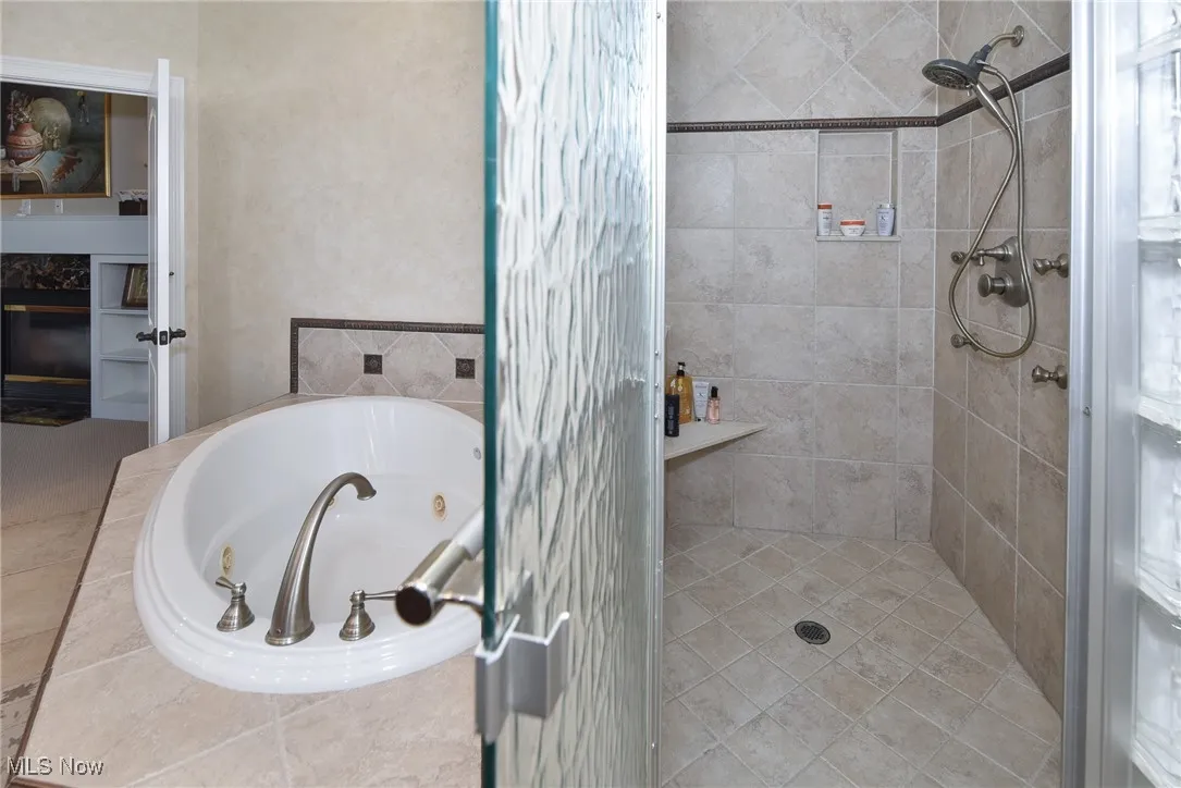 Bathroom featuring a shower stall and a jetted tub