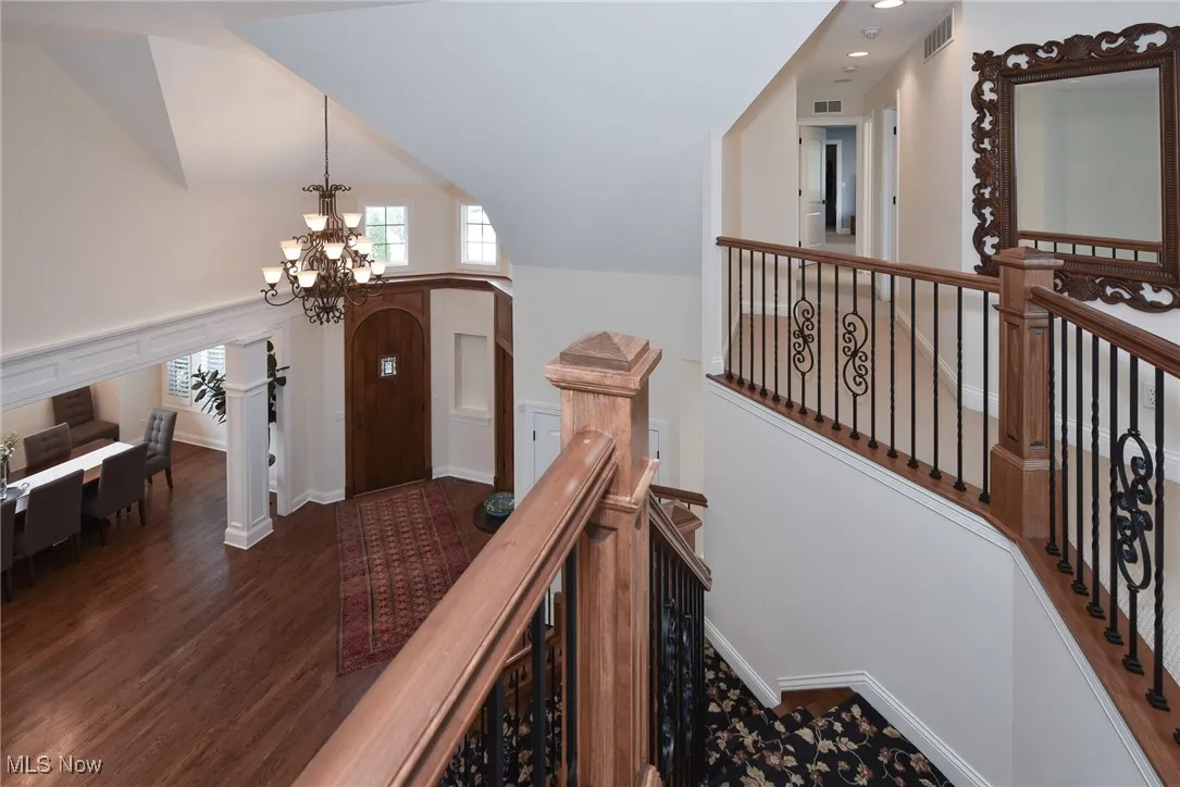 Entryway with a chandelier, dark wood-type flooring, and lofted ceiling