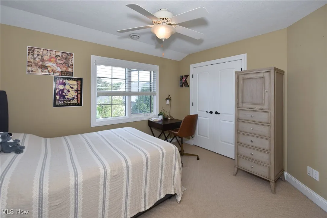 Bedroom featuring light carpet, a ceiling fan, and a closet
