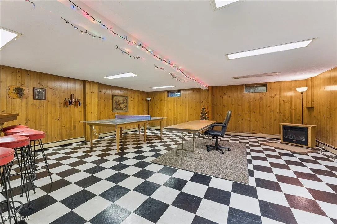 Game room featuring wooden walls and dark floors