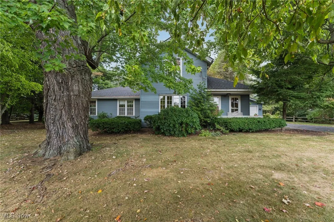 View of front of house featuring a front lawn and a shingled roof