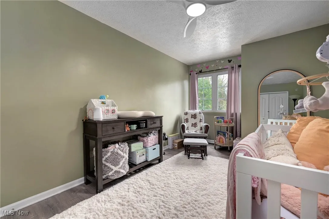 Bedroom featuring wood finished floors, a textured ceiling, and a ceiling fan