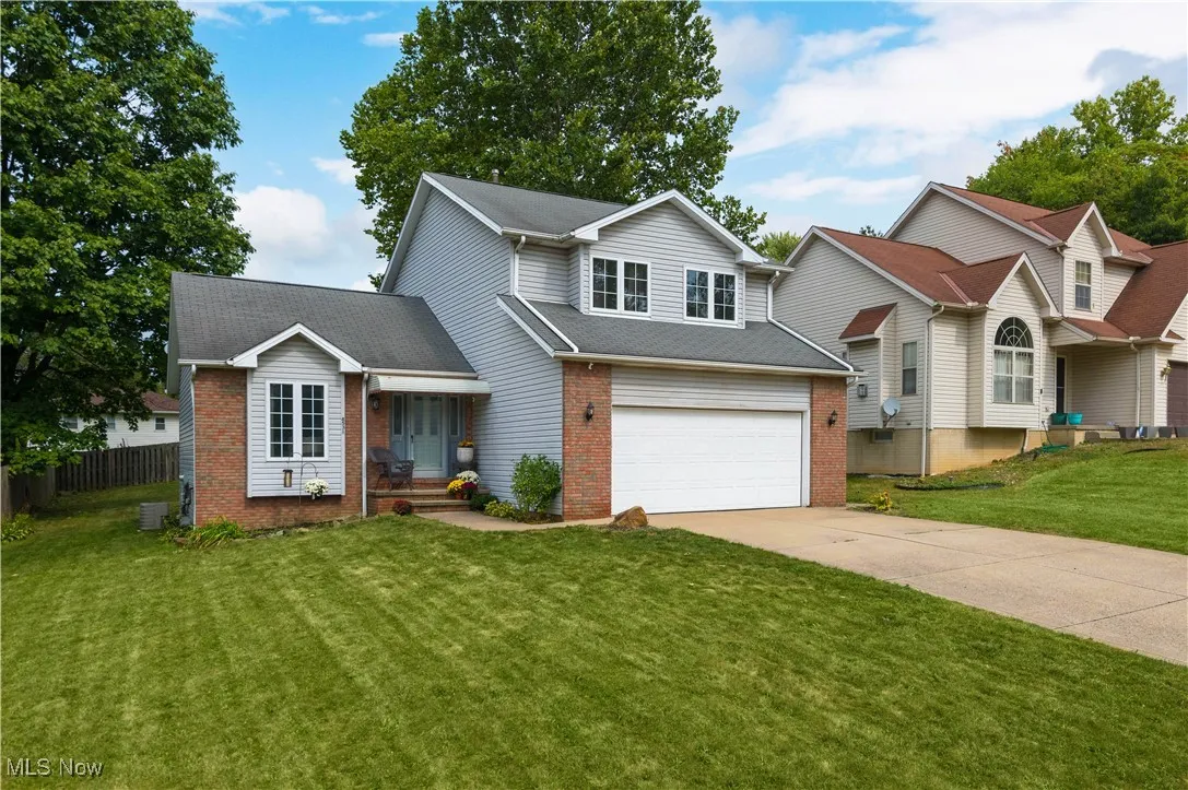 Traditional home featuring brick siding, concrete driveway, an attached garage, and a shingled roof