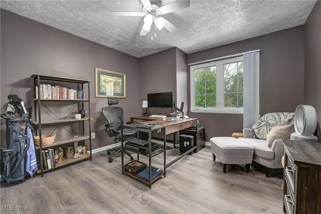 Office featuring light wood-style flooring, a textured ceiling, and ceiling fan