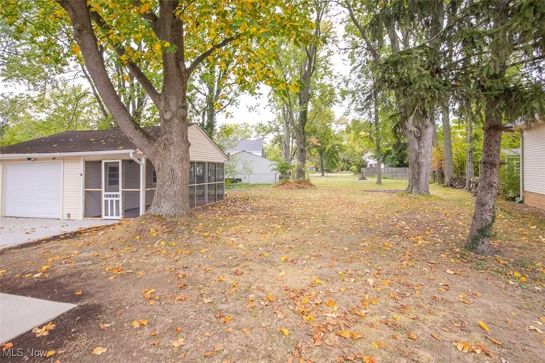 View of yard with a garage and a sunroom