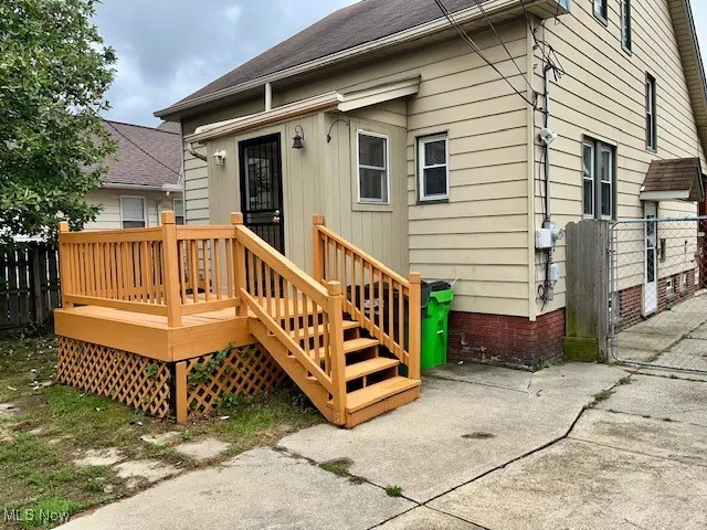 Rear view of property with a deck, a gate, and roof with shingles