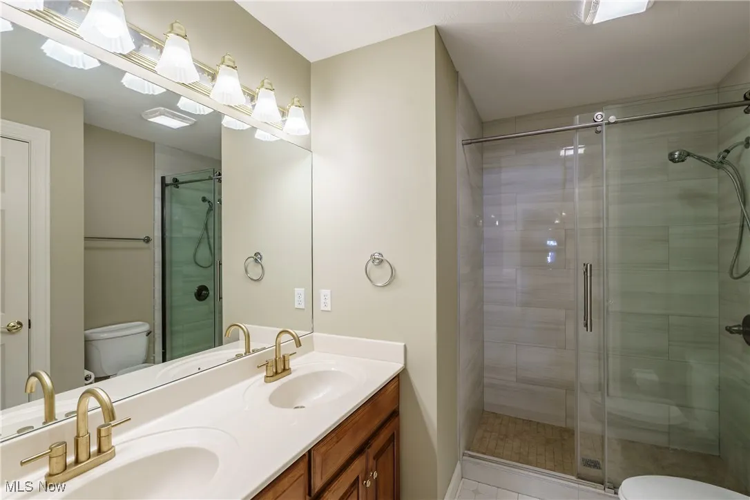 Large hall bath with tiled shower and roller glass doors.
