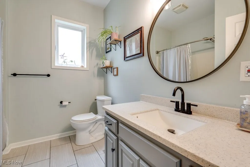 Bathroom with vanity, a shower with curtain, and light tile patterned flooring