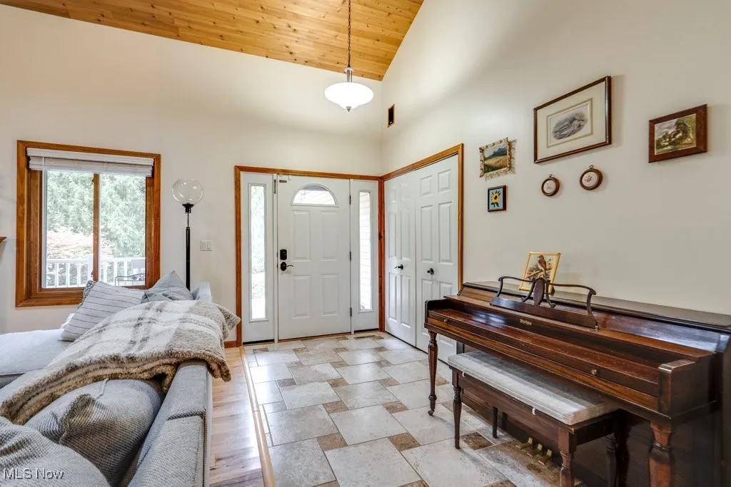 Foyer entrance with high vaulted ceiling and wooden ceiling