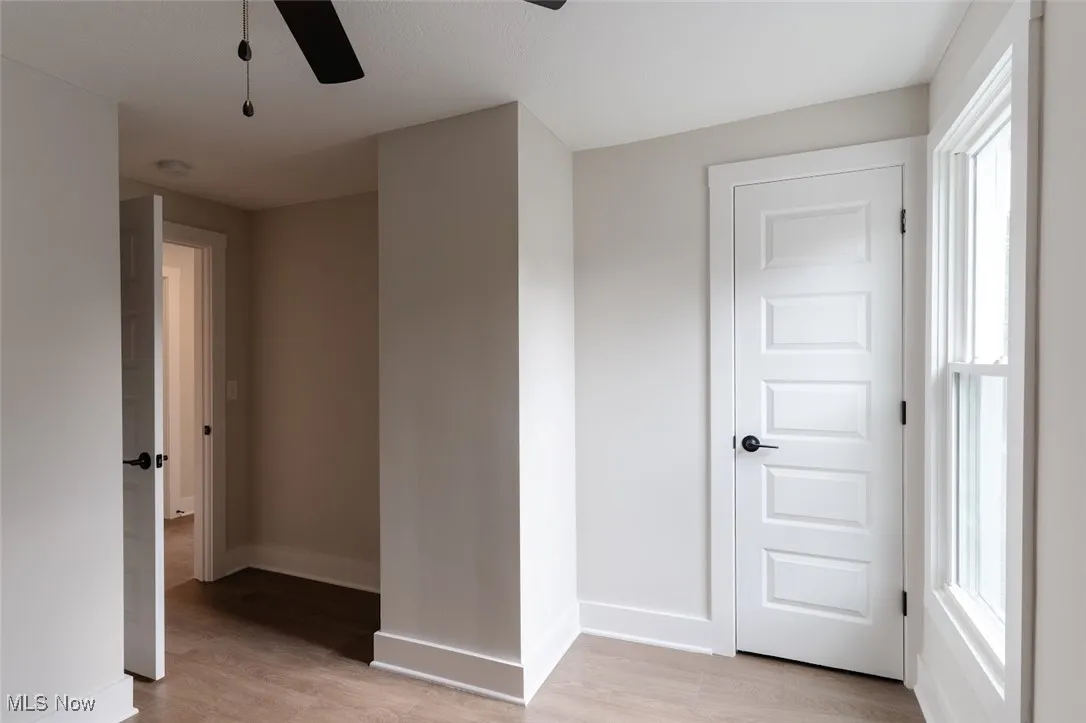 Empty room with light wood-type flooring and a ceiling fan