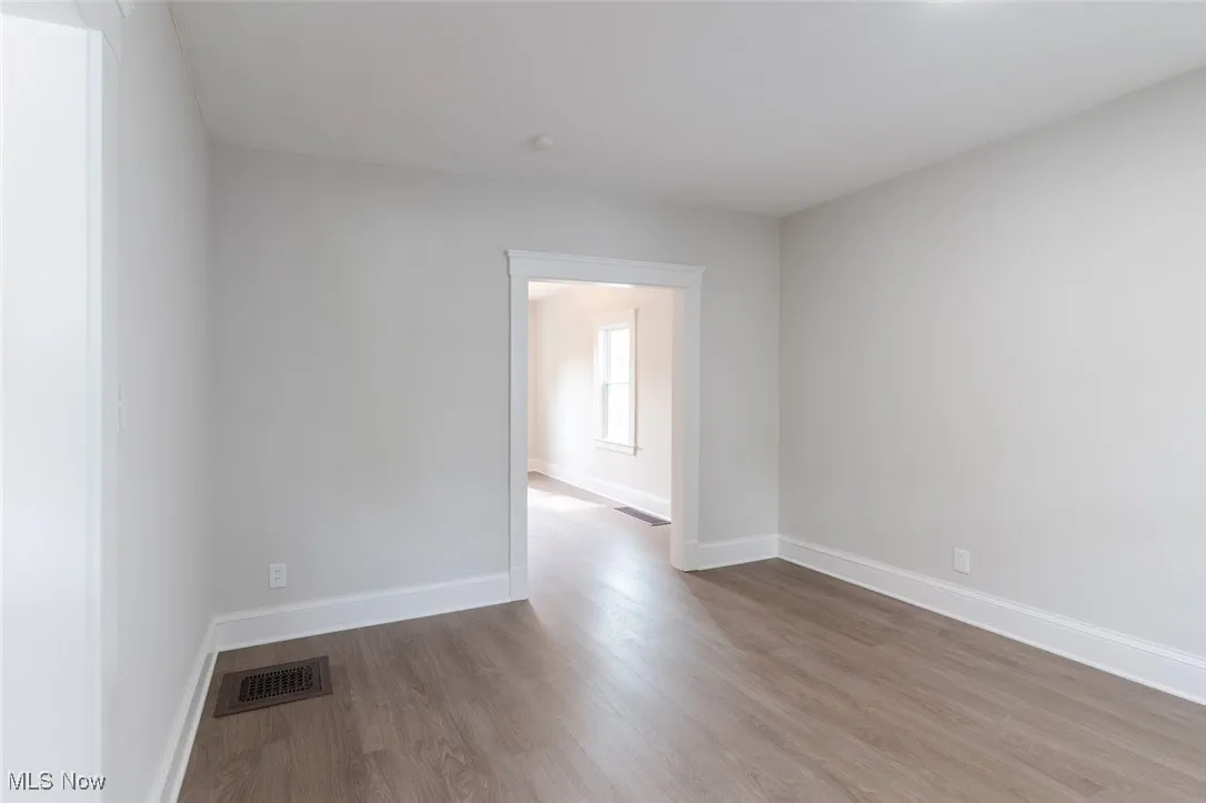 Unfurnished room with wood finished floors and baseboards