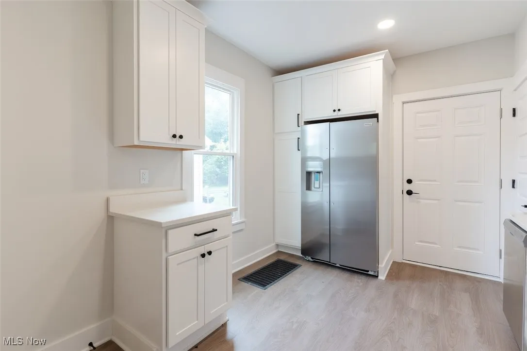 Kitchen featuring appliances with stainless steel finishes, white cabinetry, light wood-style flooring, and recessed lighting