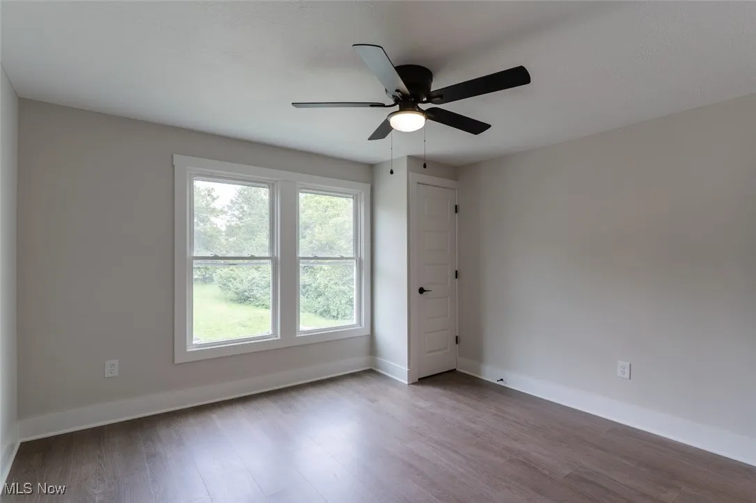 Empty room with wood finished floors and ceiling fan