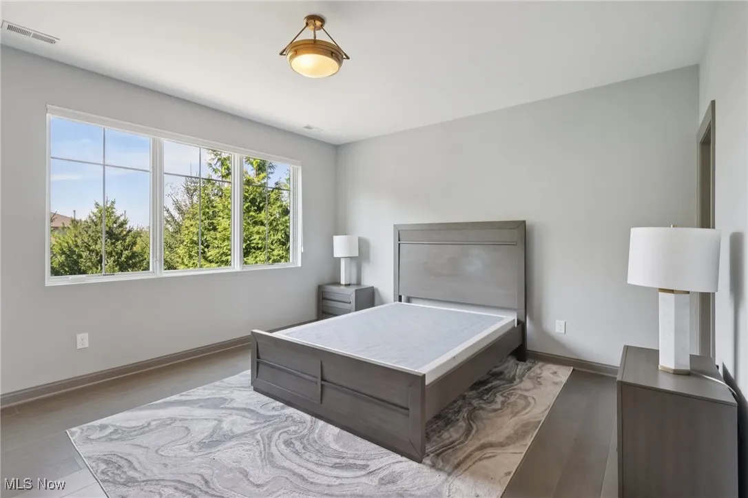 Bedroom with wood finished floors and baseboards