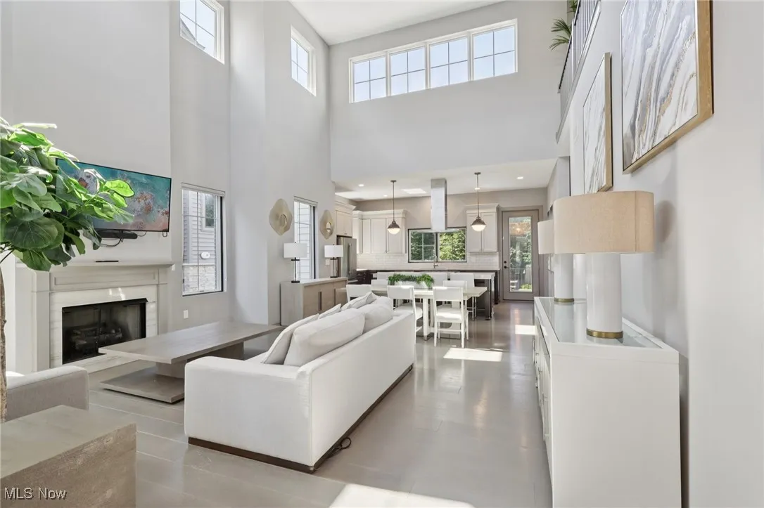 Living area featuring a fireplace, healthy amount of natural light, and a towering ceiling