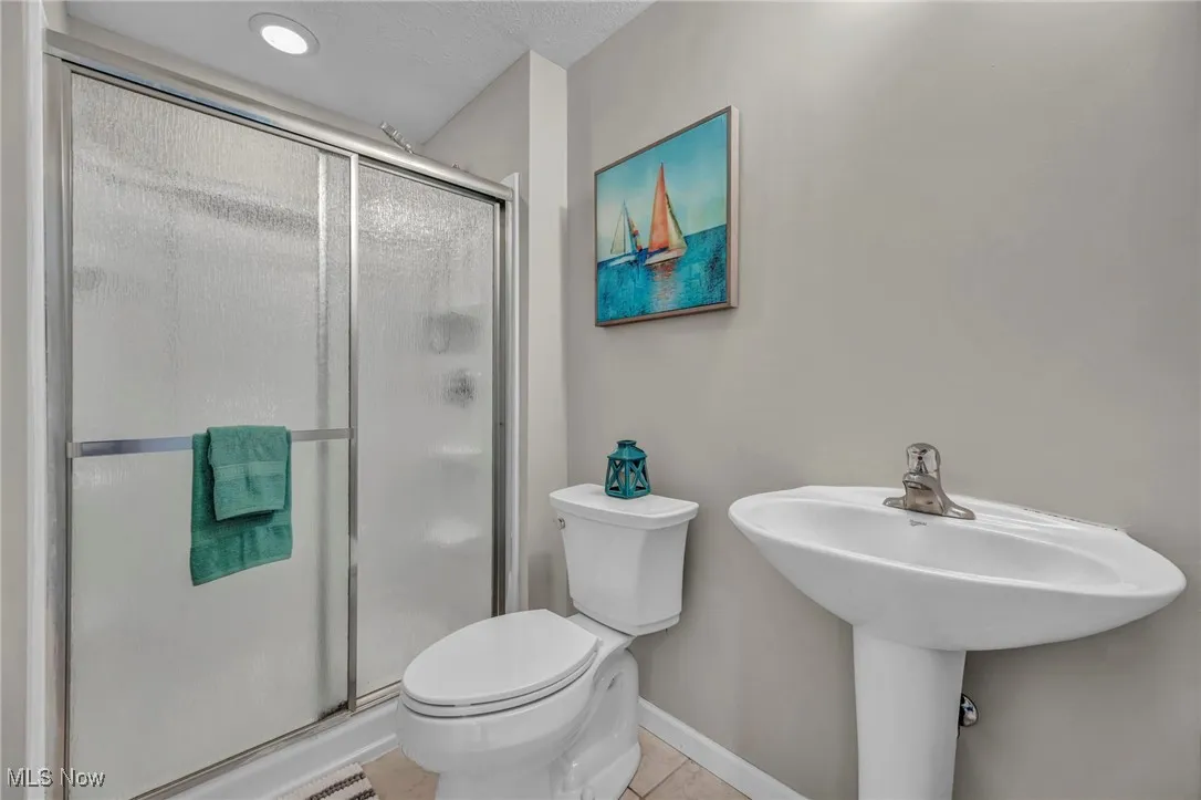 Bathroom with a stall shower and tile patterned flooring