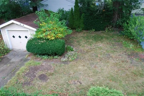 View of yard featuring a garage and an outdoor structure