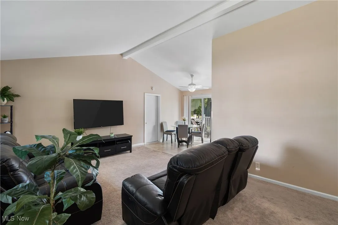 Living area with light carpet and ceiling fan