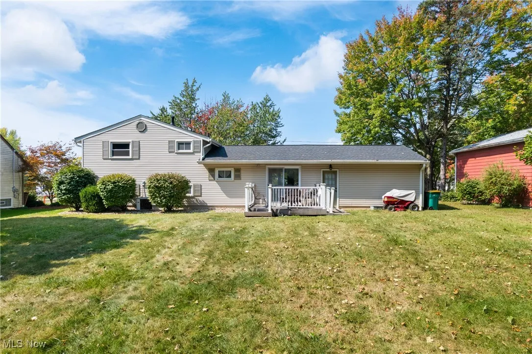 Rear view of property featuring a yard and a deck