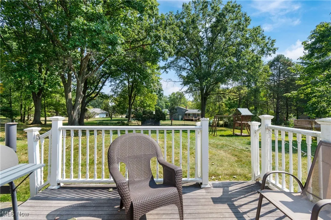 Wooden railings with a yard and view of scattered trees