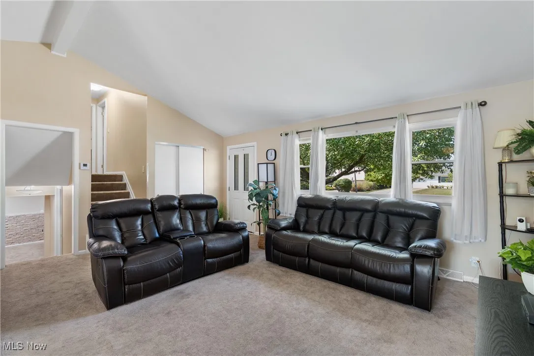 Living room with carpet flooring and stairs