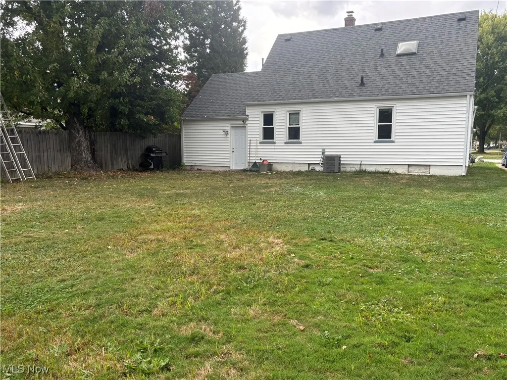Rear view of house with a chimney and a shingled roof