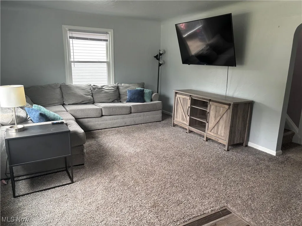 Carpeted living room featuring baseboards