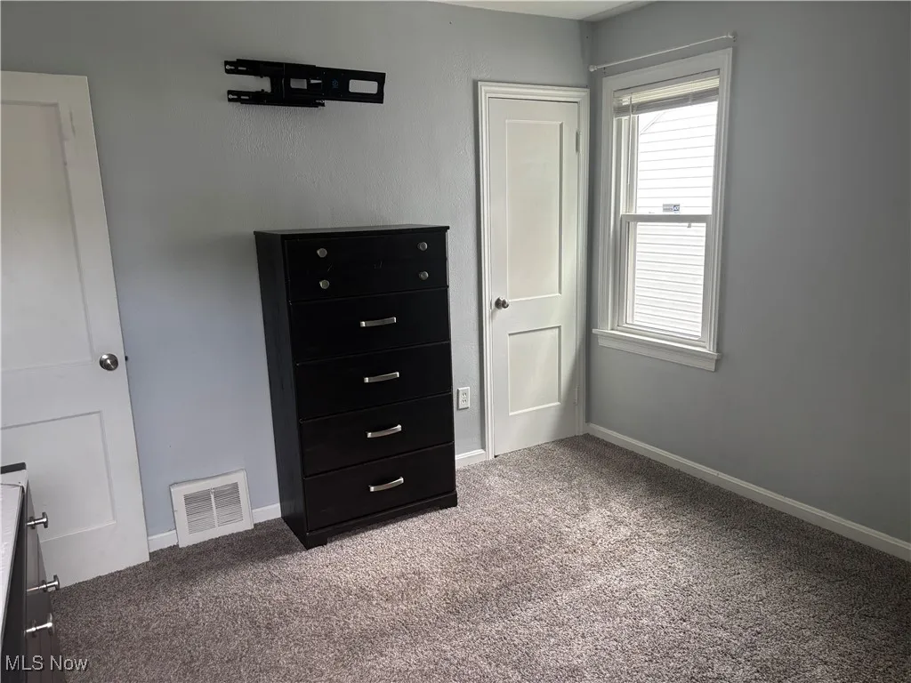 Unfurnished bedroom featuring carpet flooring and baseboards