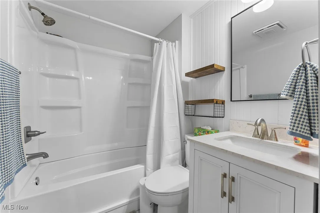View of the bathroom featuring white cabinetry and bath/tub combo