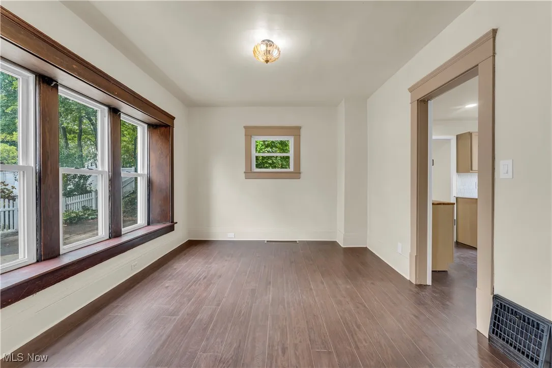 Unfurnished room featuring dark wood-style flooring and baseboards