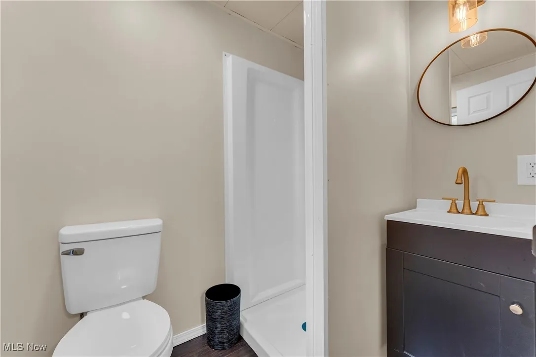 Bathroom featuring vanity, a stall shower, and dark wood-style floors