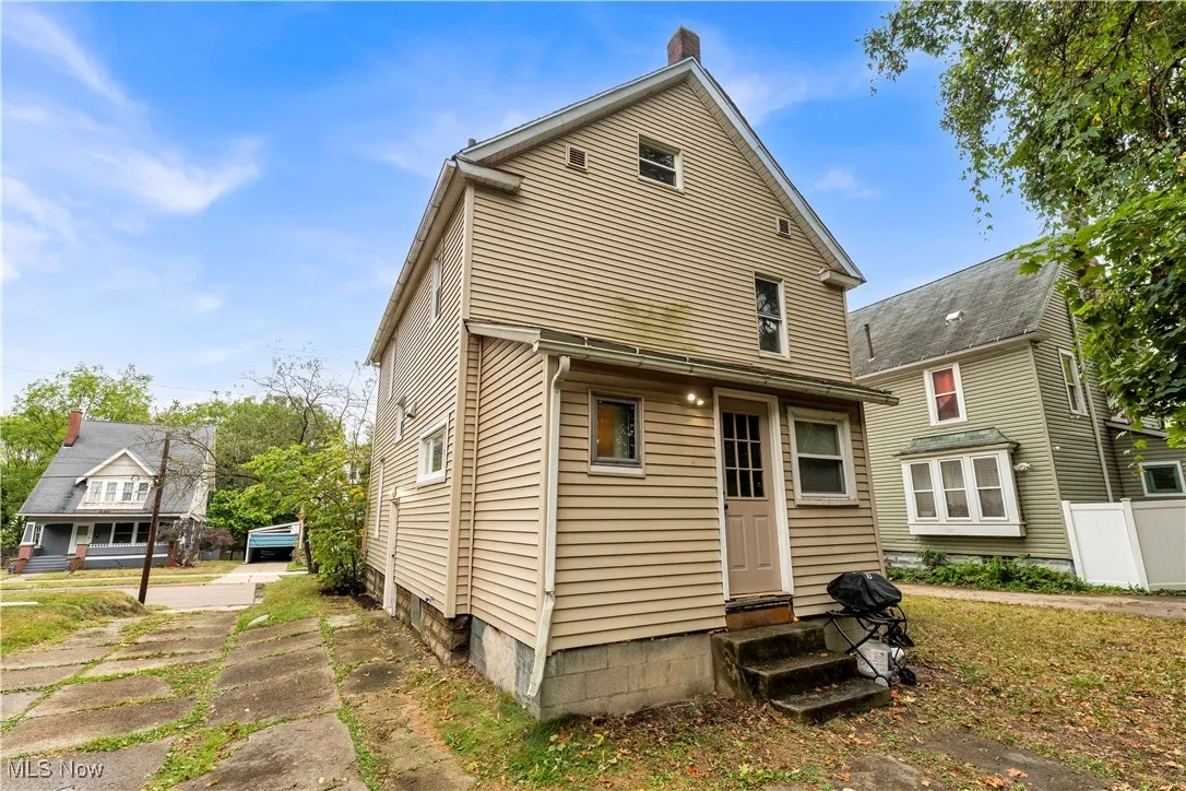 Back of property featuring entry steps and a chimney