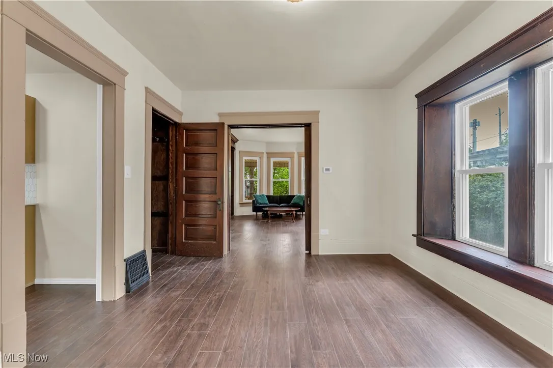 Unfurnished room with dark wood finished floors and baseboards