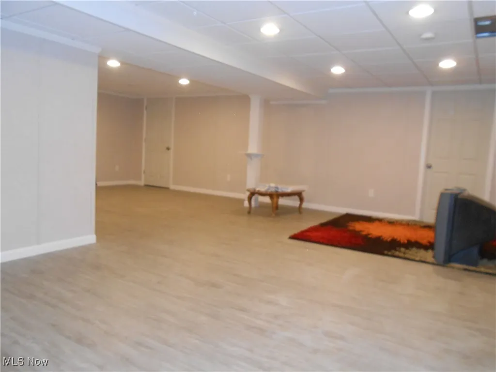 Finished basement with light wood-type flooring and recessed lighting