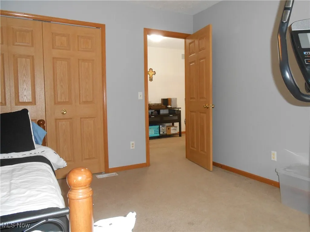 Bedroom with light carpet and baseboards